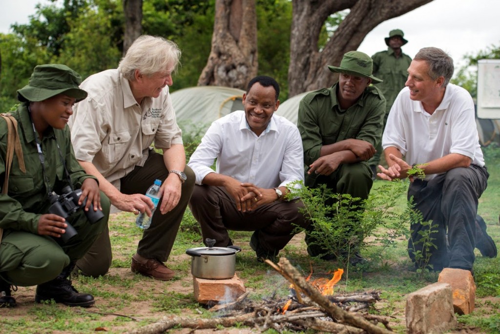 German Ambassador Egon Kochanke (second from left),  Tanzania Minister of Natural Resources & Tourism Lazaro Nyalandu (center), and U.S. Ambassador Mark Childress (right) talk with Tanzanian game scouts from the Selous Game Reserve at an equipment handover ceremony.