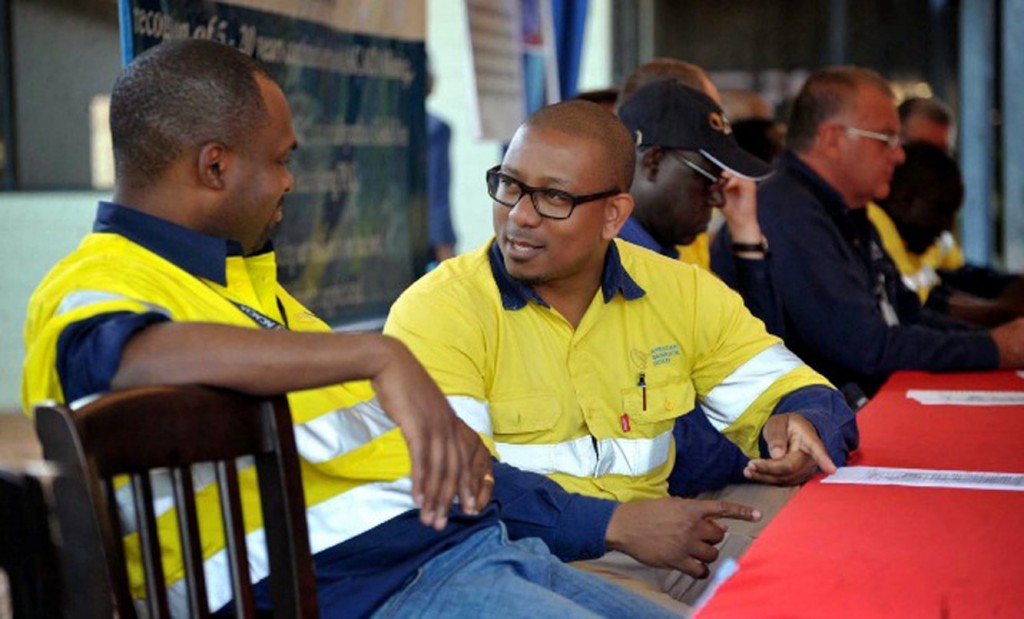 The Principal Medical consultant for ACACIA Gold Mining in Tanzania Dr. Zumbi Elvis Musiba, (R-in glasses), Discusses an issue with Director of Commercial services at Bulyanhulu gold mine, Benedict Busunzu during a ceremony April 28, 2015, to award best workers at the gold mine