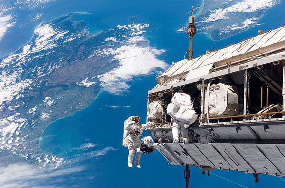 Astronauts Robert Curbeam, Jr. and Christer Fuglesang working on the International Space Station.